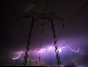 Nighttime lightning storm over electric power line towers.