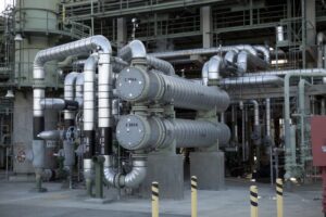 A gray and silver circulation pump system outside of an industrial facility.